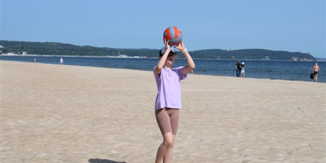 Powiększ grafikę: Dziewczynka z piłką na plaży