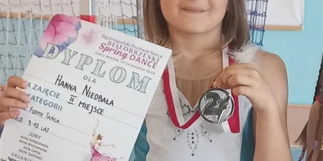 Powiększ grafikę: Uczennica z dyplomem i medalem