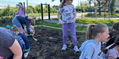 Powiększ grafikę: Uczniowie podczas siania łąki