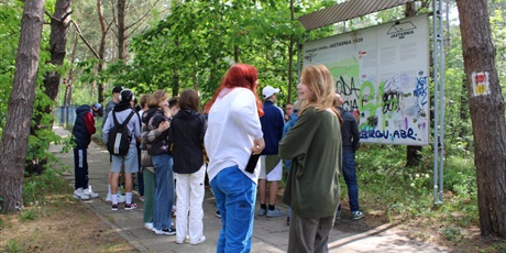 Powiększ grafikę: Uczniowie stojący przed tablicą informacyjną